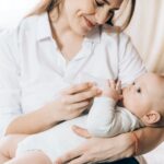 Mother bottle-feeding newborn baby image supporting KeyWord feeding and care content